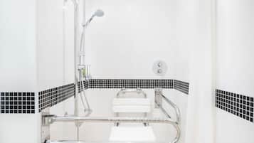 Ein Badezimmer mit Dusche, Toilette und Handlauf.