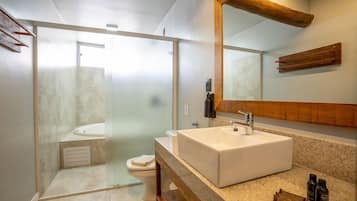 Ein modernes Badezimmer mit einer Duschkabine, einem weißen Waschbecken und einer Holzausstattung.