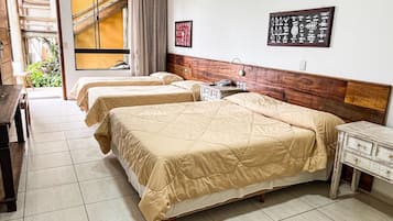 A hotel room with two beds, a wooden headboard, a desk, and a chair.