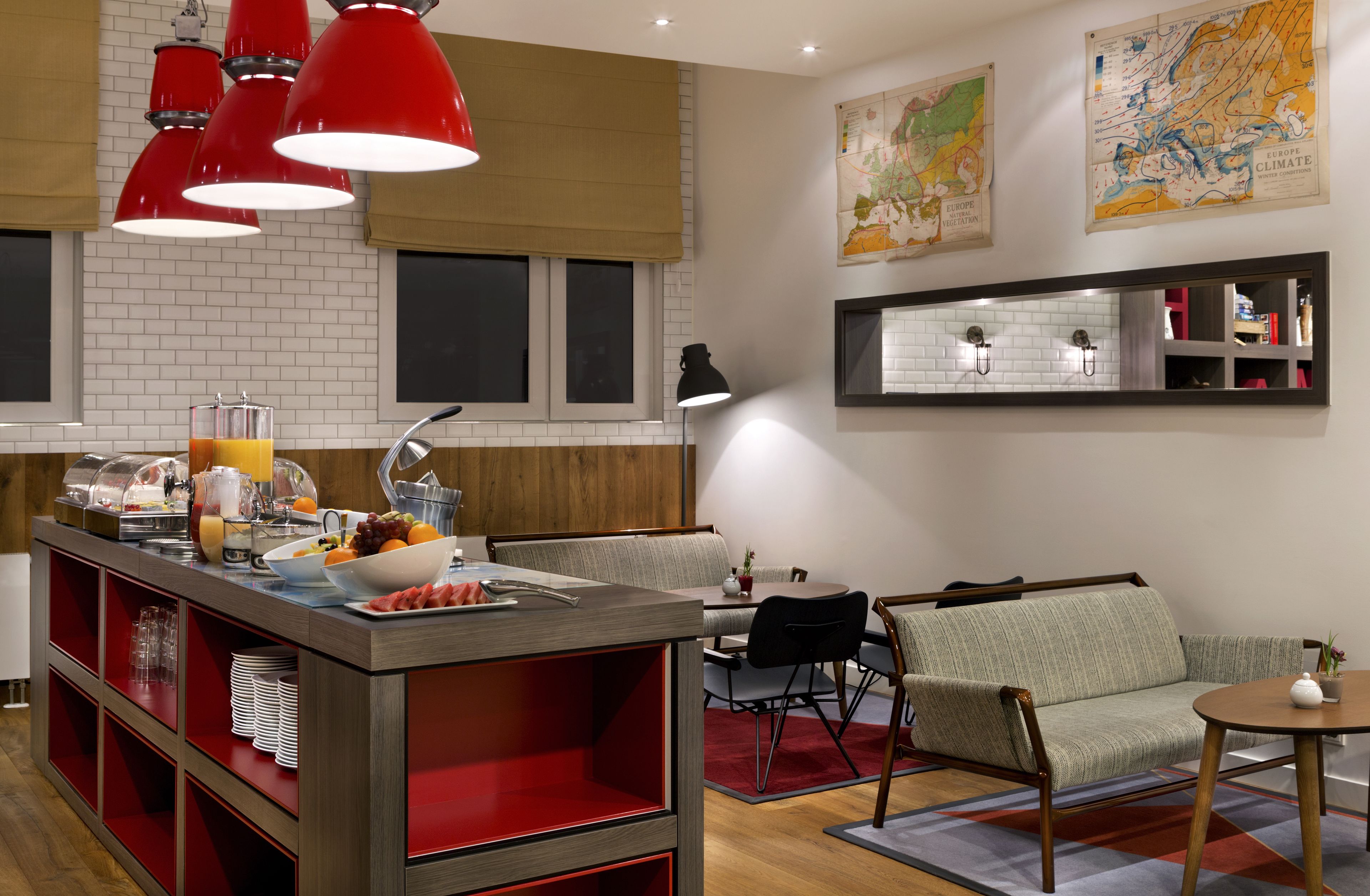 Una cocina moderna con barra de desayuno, luces colgantes rojas y un mapa en la pared.