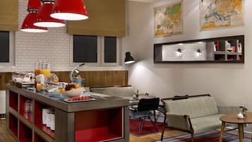 Una cocina moderna con barra de desayuno, luces colgantes rojas y un mapa en la pared.