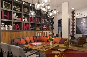 Un salon moderne comprenant un canapé, des fauteuils, une table basse et une bibliothèque sur laquelle sont disposées de grandes lettres formant un mot.