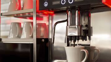 A coffee machine with a digital display and a cup of coffee being dispensed.