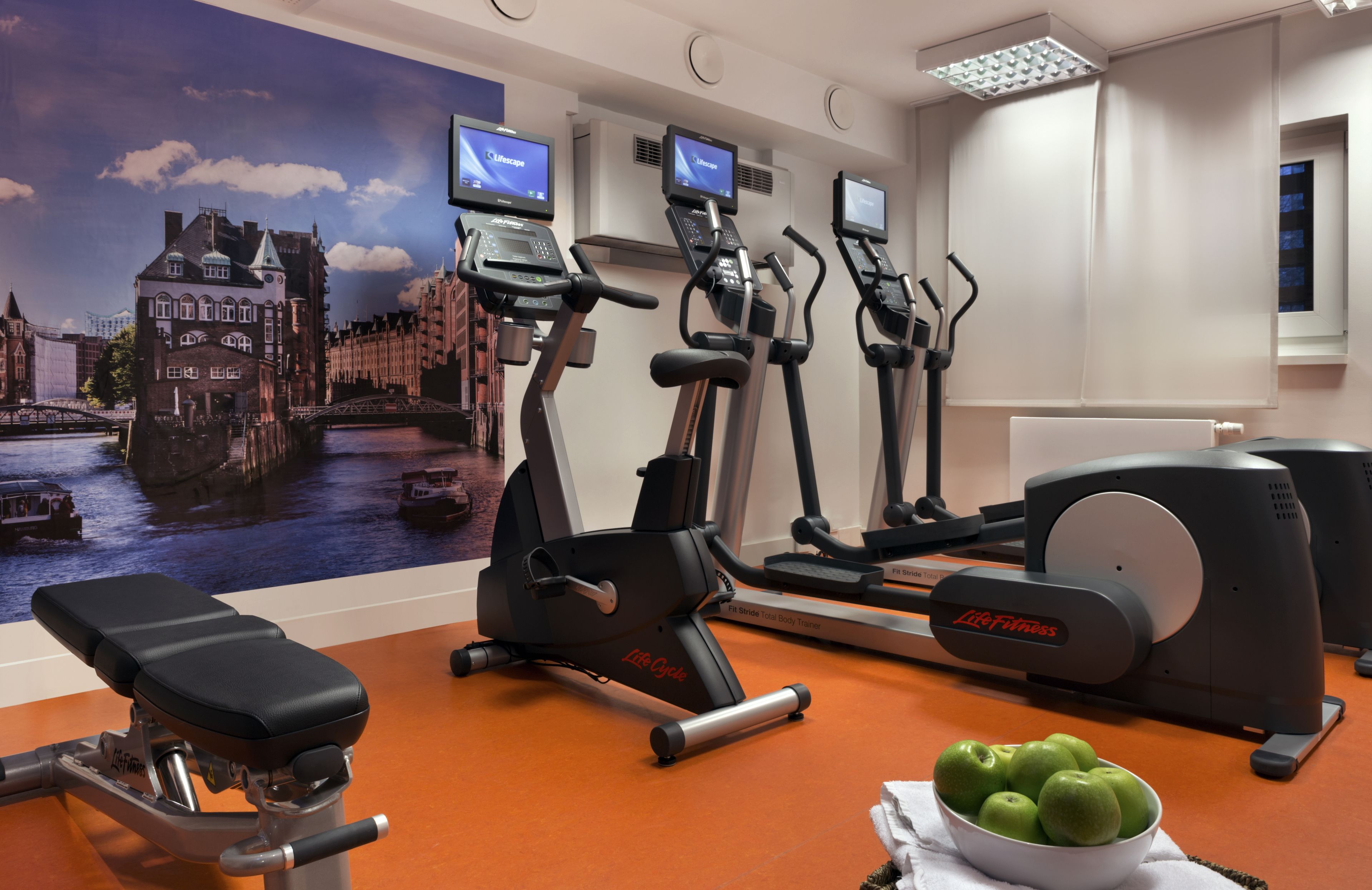 A gym with treadmills, a stationary bike, and a bench.