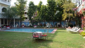 Relax by the pool surrounded by lush greenery and enjoy a meal or a moment of tranquility.
