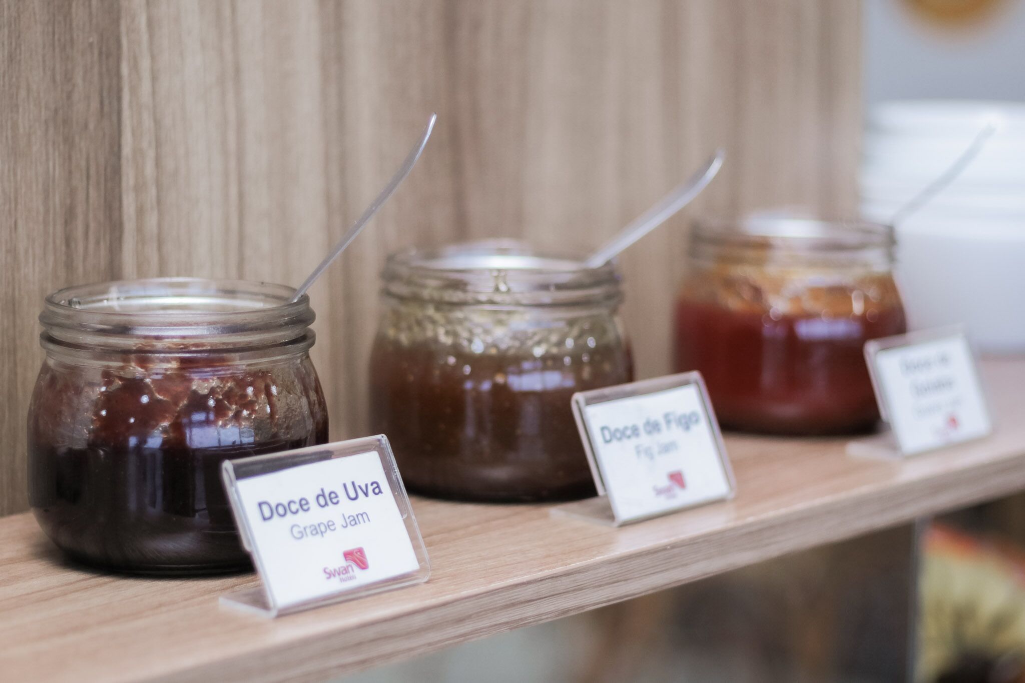 Drei Marmeladengläser auf einer Holzwand mit Etiketten.