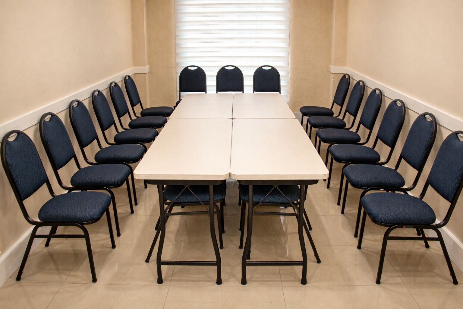 Ein Konferenzraum mit einem langen Tisch und Stühlen darum herum.
