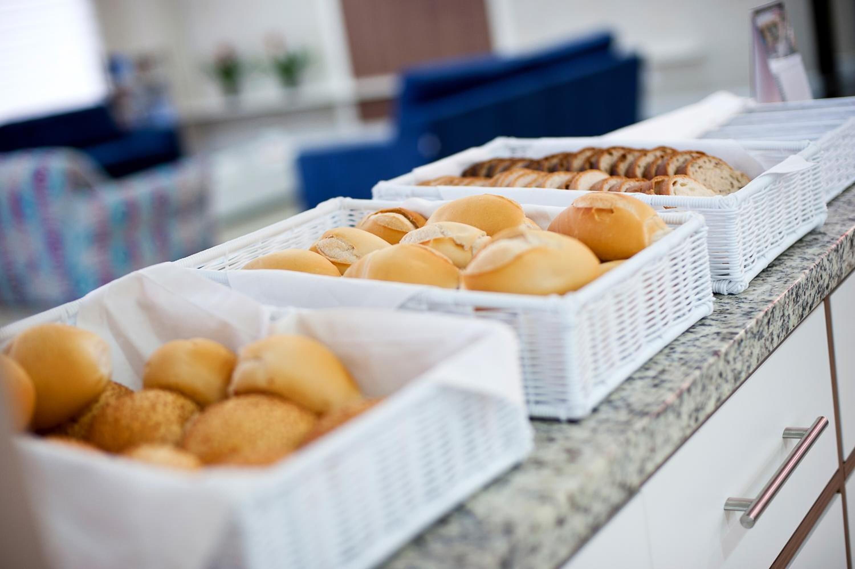 Un bufé con diversas opciones de panadería, incluyendo panecillos y pasteles.