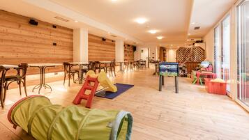 Relax and unwind in our family-friendly common area, featuring a play structure, seating areas, and a TV.