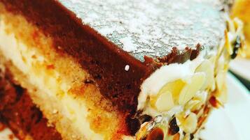 A slice of layered dessert with a creamy filling and a chocolate topping.
