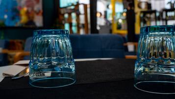 Een tafel met twee glazen drinkglazen en een zwart tafelkleed in een restaurant.