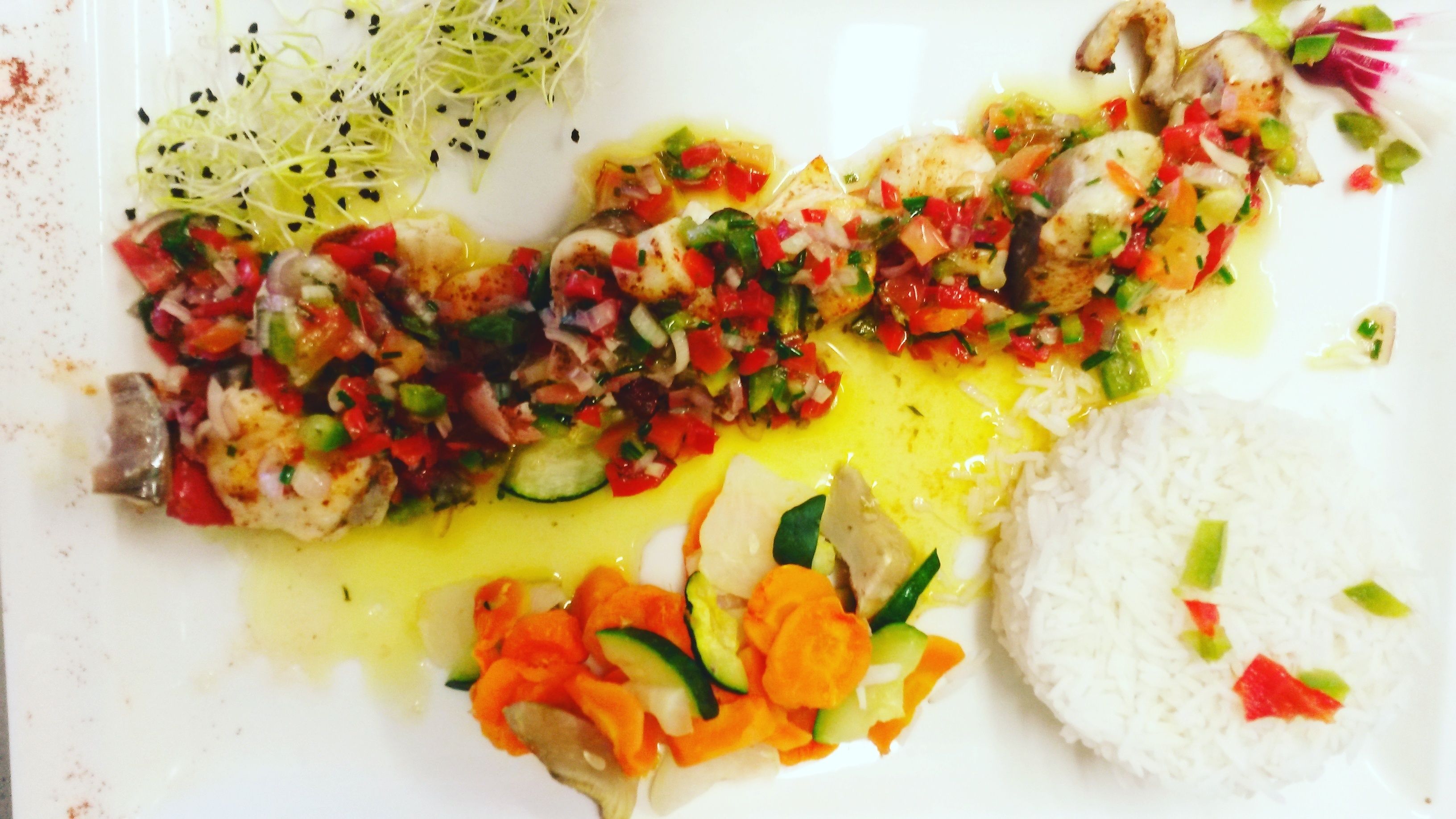 A plate with fish, rice, and vegetables.