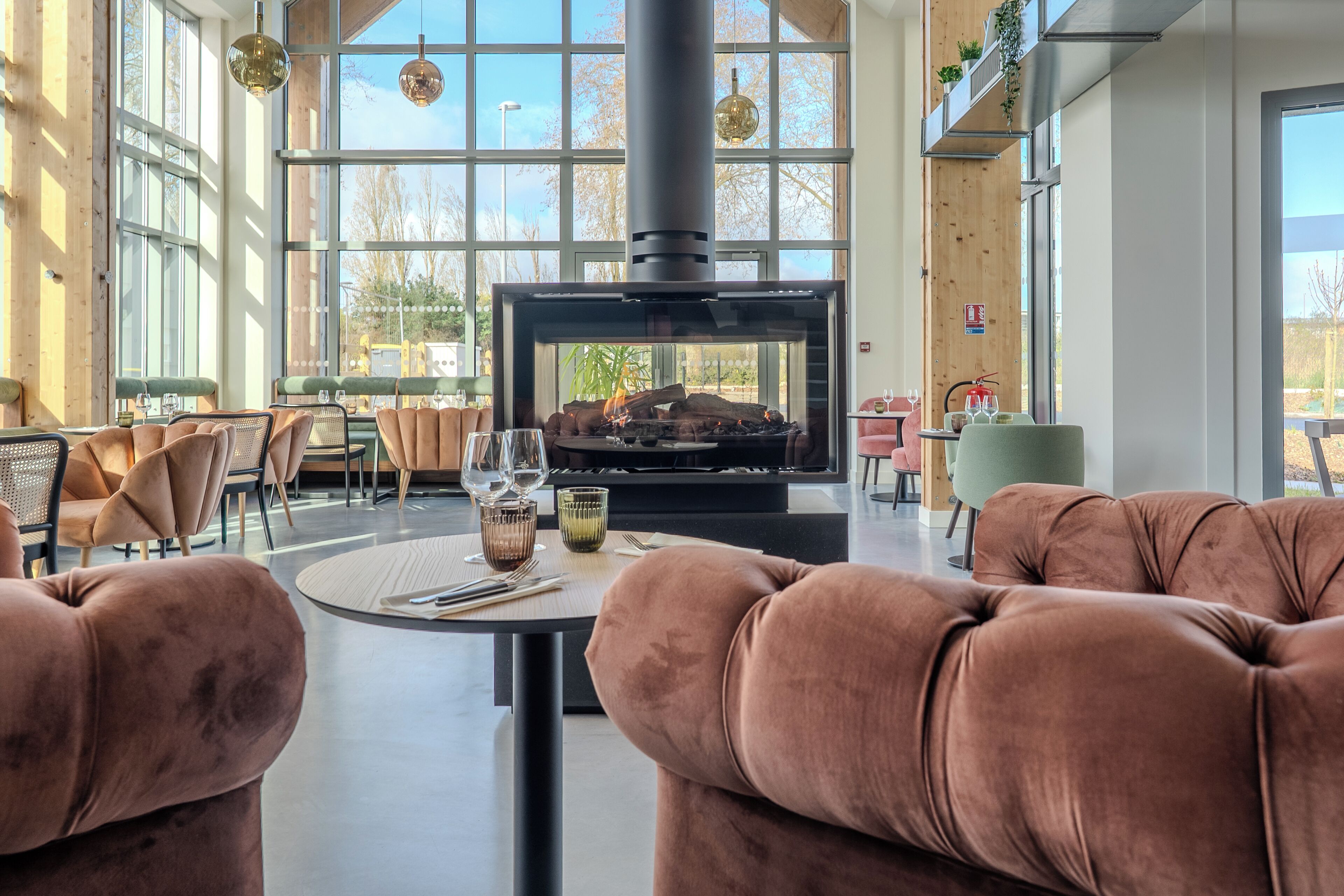 Cómoda zona de estar con sofás mullidos y una mesa dispuesta para comer, con vista a una chimenea moderna.