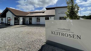 Un hotel moderno con un camino de grava y un cartel que dice "strandhotel KLITROSEN".