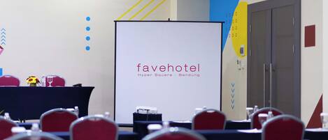 Uma sala de conferências com uma tela de projeção exibindo 'favehotel Hyper Square - Bandung'.