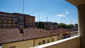 A view of a building with multiple floors and a tiled roof, featuring balconies and a clear sky. - Patty's Aparthotel Arezzo (Arezzo)