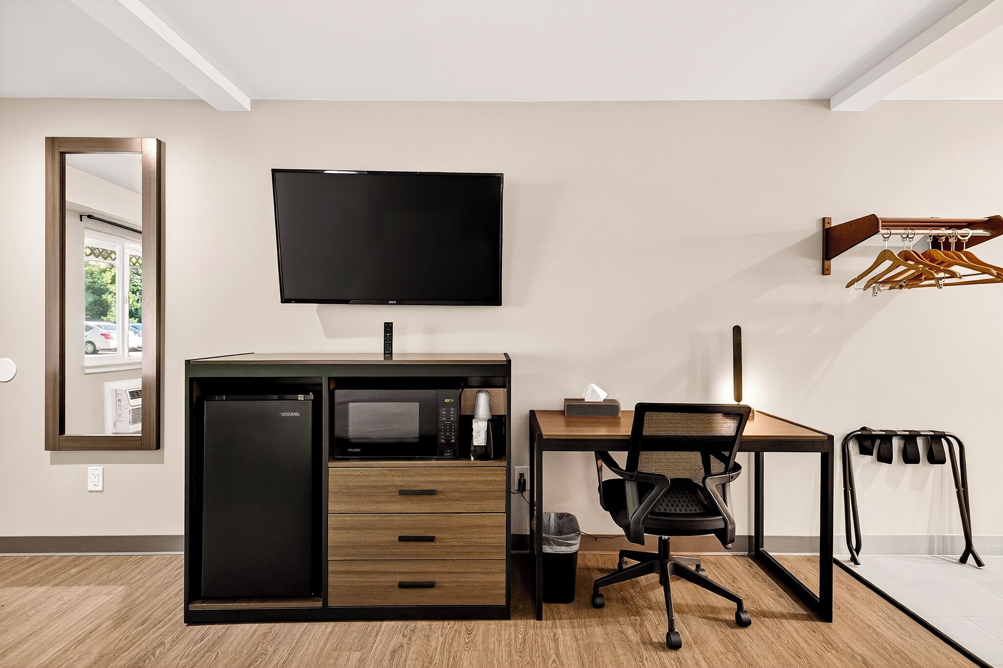 A modern office space with a desk, chair, and a flat-screen TV.
