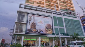 Un edificio de varios pisos con un cartel llamativo que anuncia un restaurante.