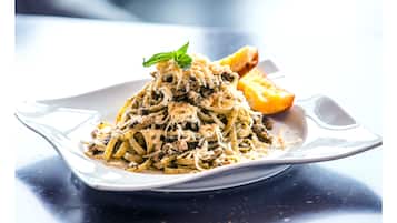 Eine Pasta-Kombination mit Garnitur auf einem weißen Teller.