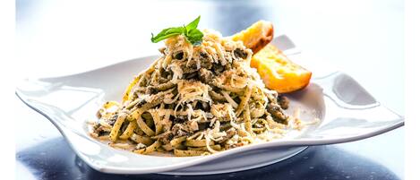A plate of pasta with a garnish on a white plate.
