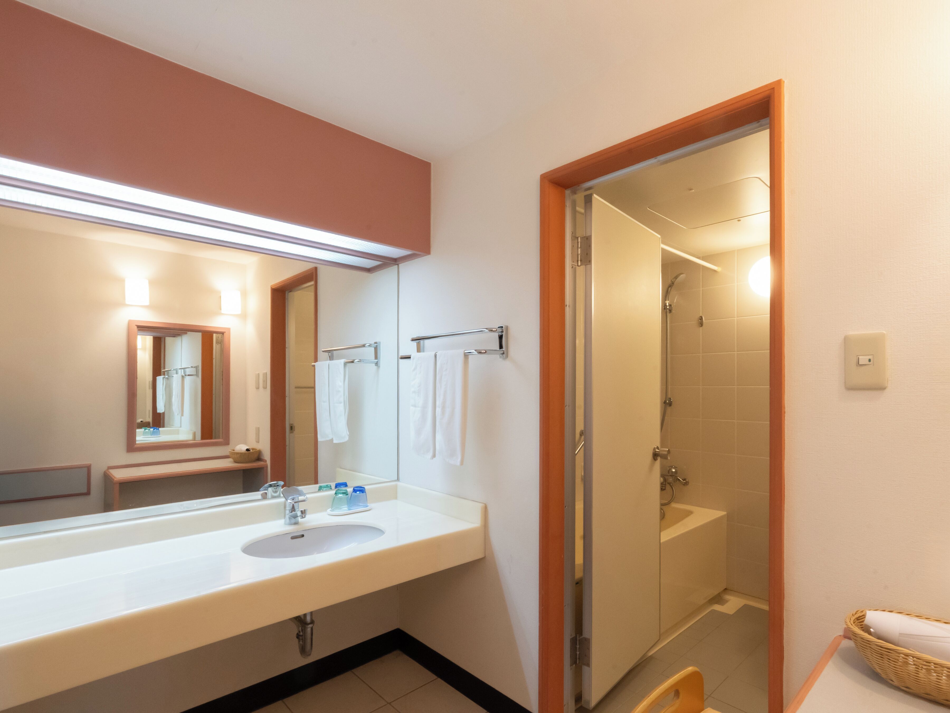Un baño con lavamanos, espejo y ducha.
