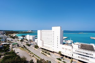A high-rise hotel with a view of the sea and a marina.