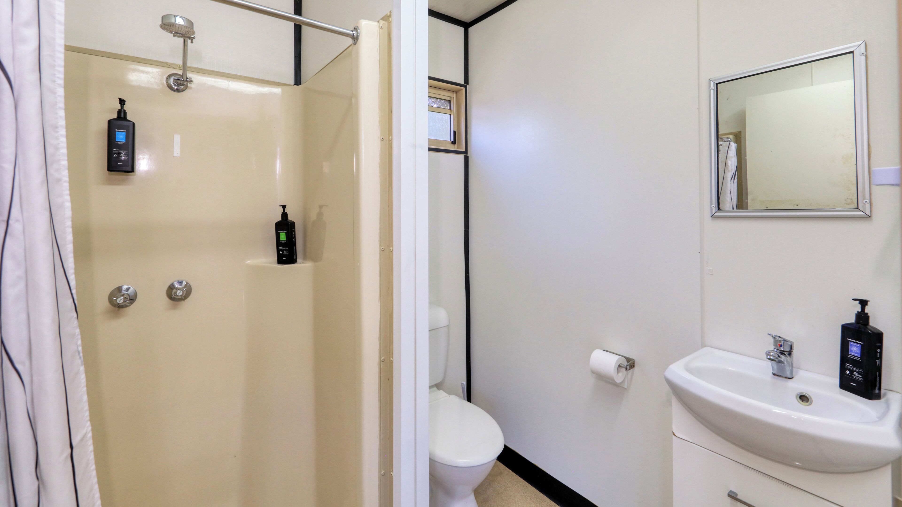 Un baño con ducha, inodoro y lavabo.