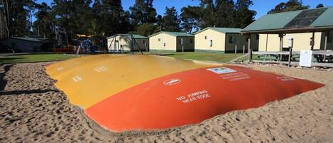 A beach with a safety zone marked by a red and yellow mat with a no-jumping warning.