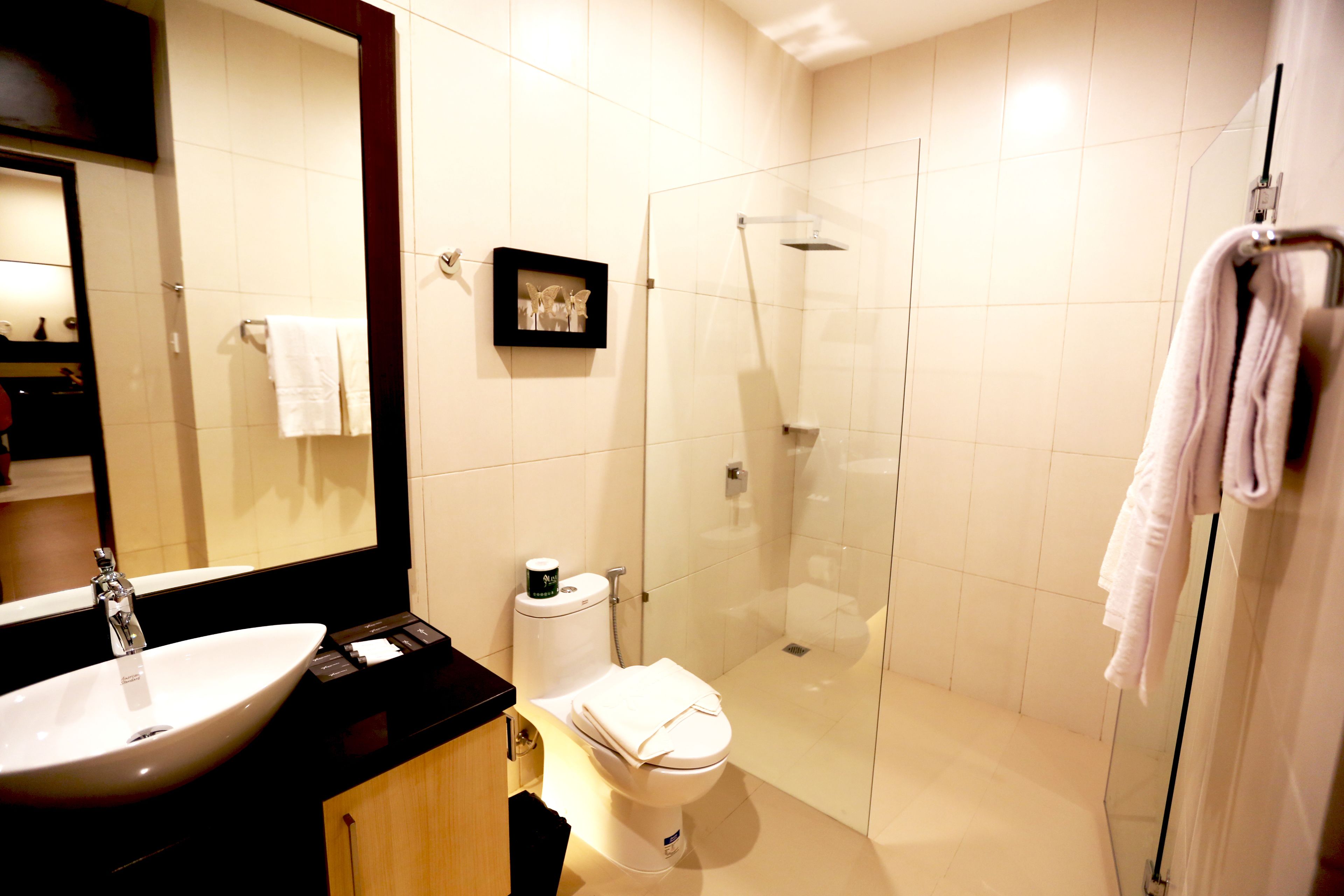 A modern bathroom with a large sink, toilet, and glass-enclosed shower.