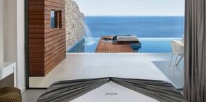 Una habitación moderna con vista al mar, una pared de madera y una pequeña piscina infinita.