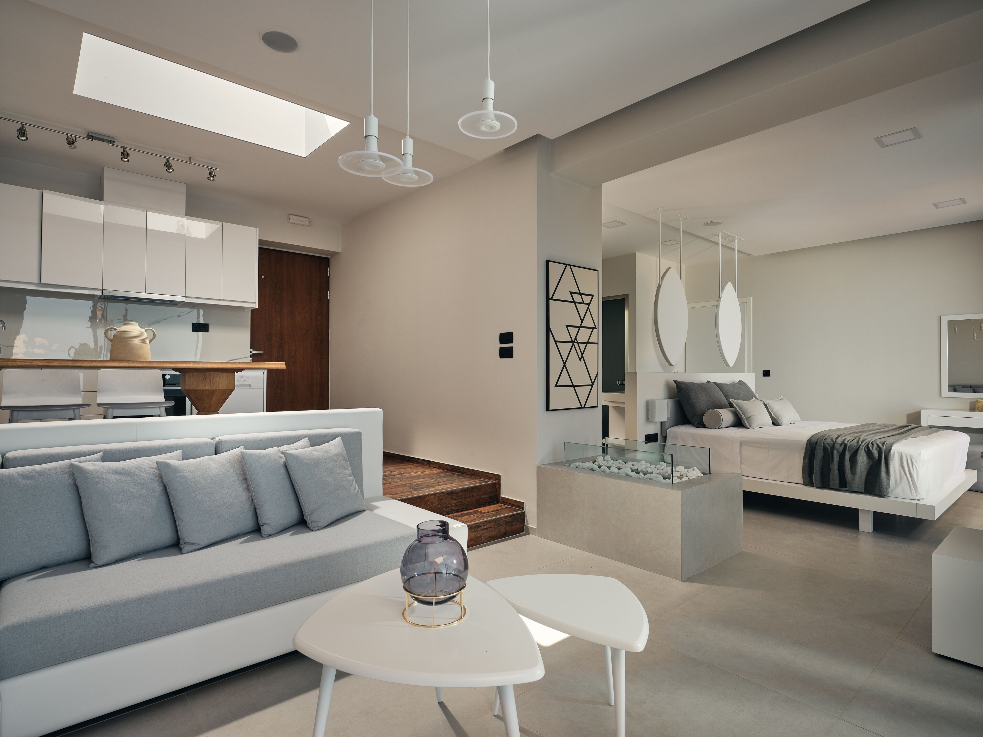 A modern interior with a sofa, a small table, and a glass-top coffee table.