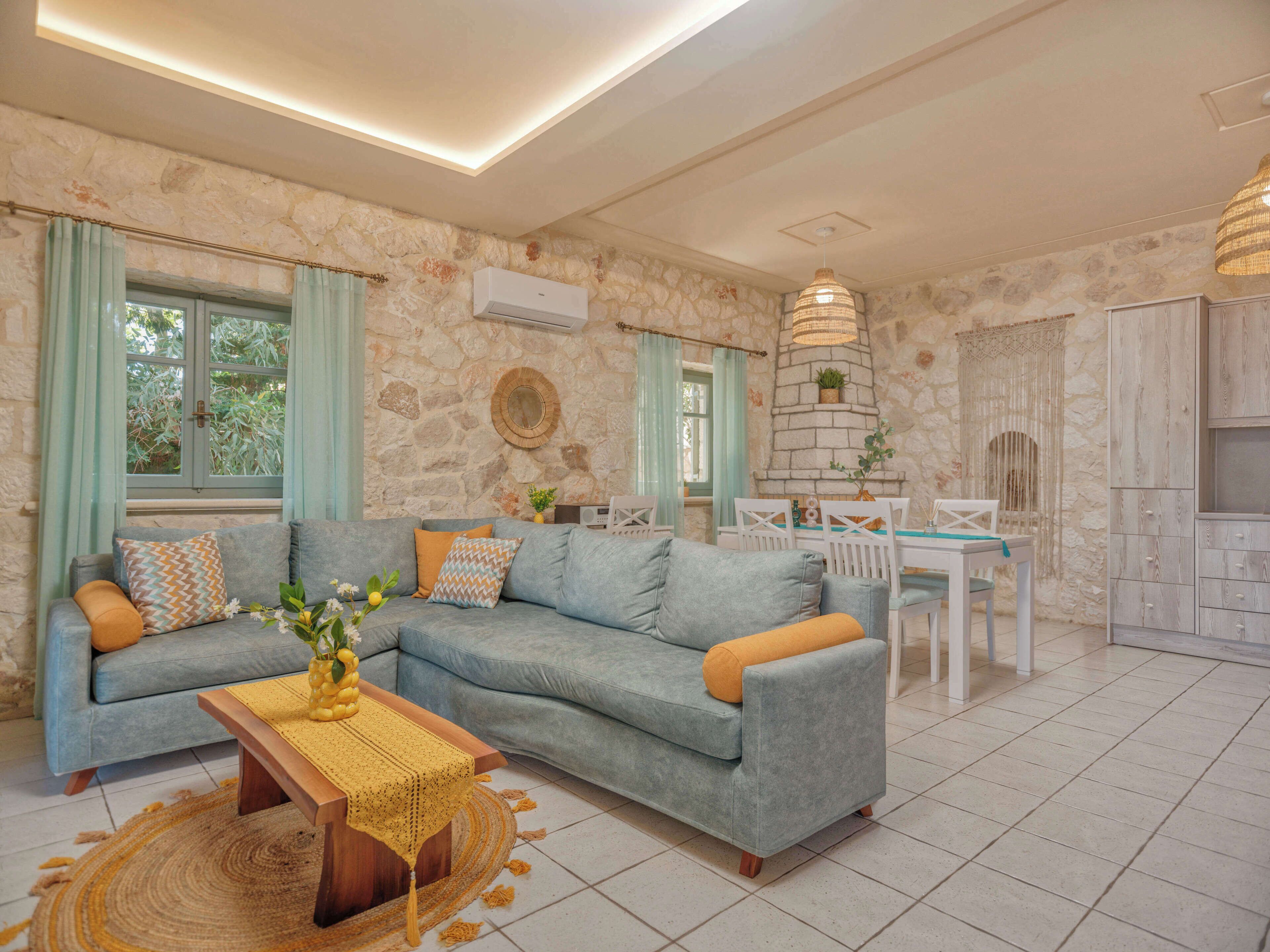 A living room with a sectional sofa, a wooden coffee table, and a dining area with a white table and chairs.