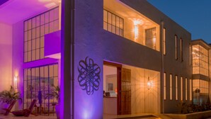 A modern two-story building with large windows and a well-lit entrance. - Latitude 15 Degrees (Lusaka)