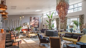 A spacious living area with a bar, seating arrangements, and large windows providing natural light. - Latitude 15 Degrees (Lusaka)