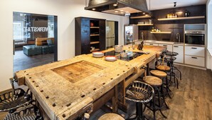 A kitchen with a large island, bar stools, and modern appliances.