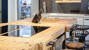 A kitchen with a wooden countertop, a built-in stove, and a sink.