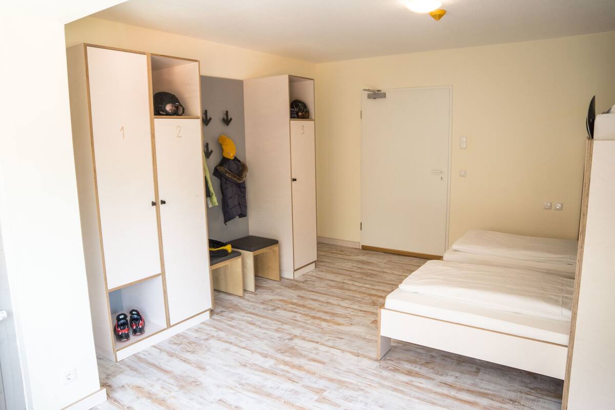 A room with a bed, a wardrobe, and a bench.