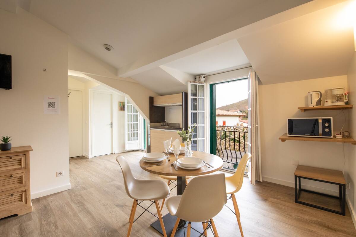 A modern kitchen with a dining area, wooden cabinets, and a view of the outside.
