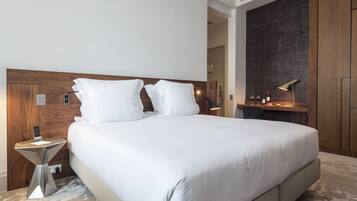 Une chambre d’hôtel moderne avec un grand lit, une table de chevet, une lampe et une armoire.
