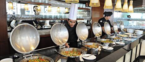 A buffet setup with multiple food stations and chefs serving.