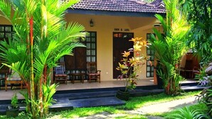 A building with a tiled roof and a sign reading "SIMON & LAURA". - Hotel Flower Garden (Unawatuna)