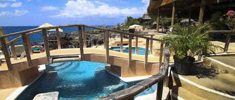 Una piscina al aire libre, sillones reclinables de piscina