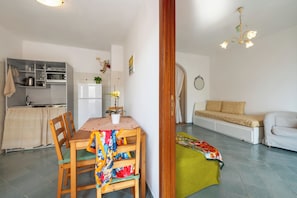 Un espace de vie compact comprenant un coin repas, une kitchenette et un coin salon.