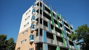 A multi-story building with a modern architectural design, featuring balconies and a clear sky in the background. - Citystay Living - Warren Close (Cambridge)