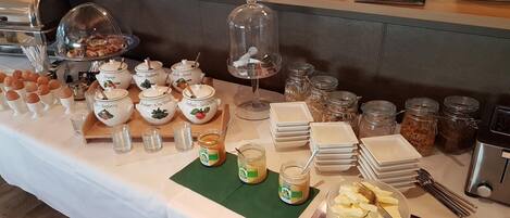 A buffet setup with various food items and serving utensils.