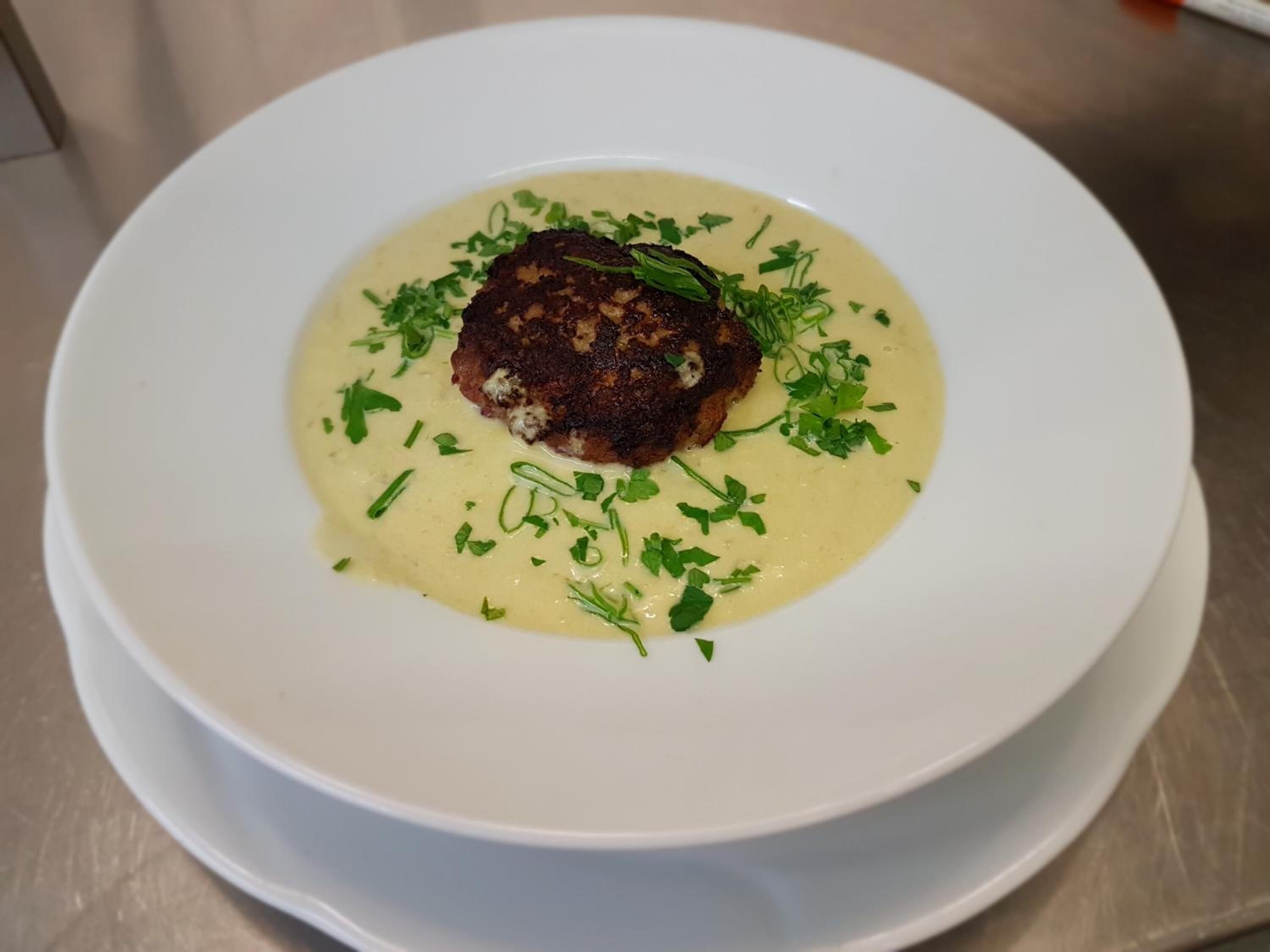 Un plato blanco con un solo alimento, adornado con hierbas verdes.