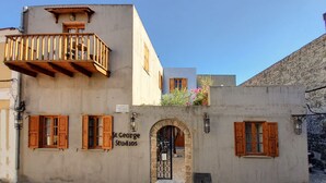 A building with a sign reading "St George Studios" and a balcony with wooden railings. - Saint George Studios (Rhodes)