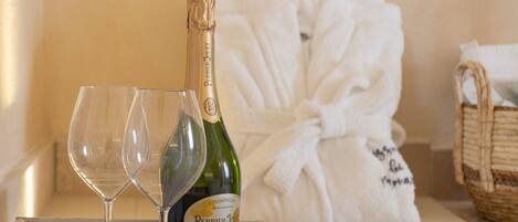 Une boîte en bois contenant une bouteille de champagne Perrier Joly et deux verres à vin.