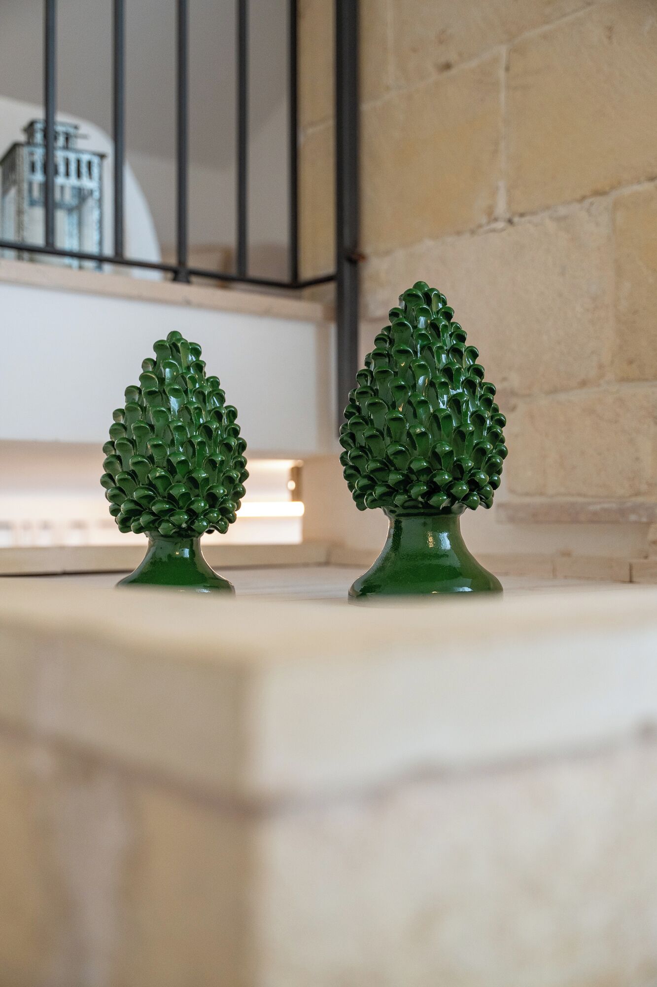 Two green decorative trees on a marble surface.
