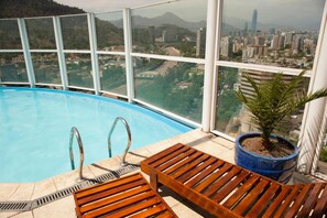Una piscina al aire libre, una piscina en la azotea, tumbonas